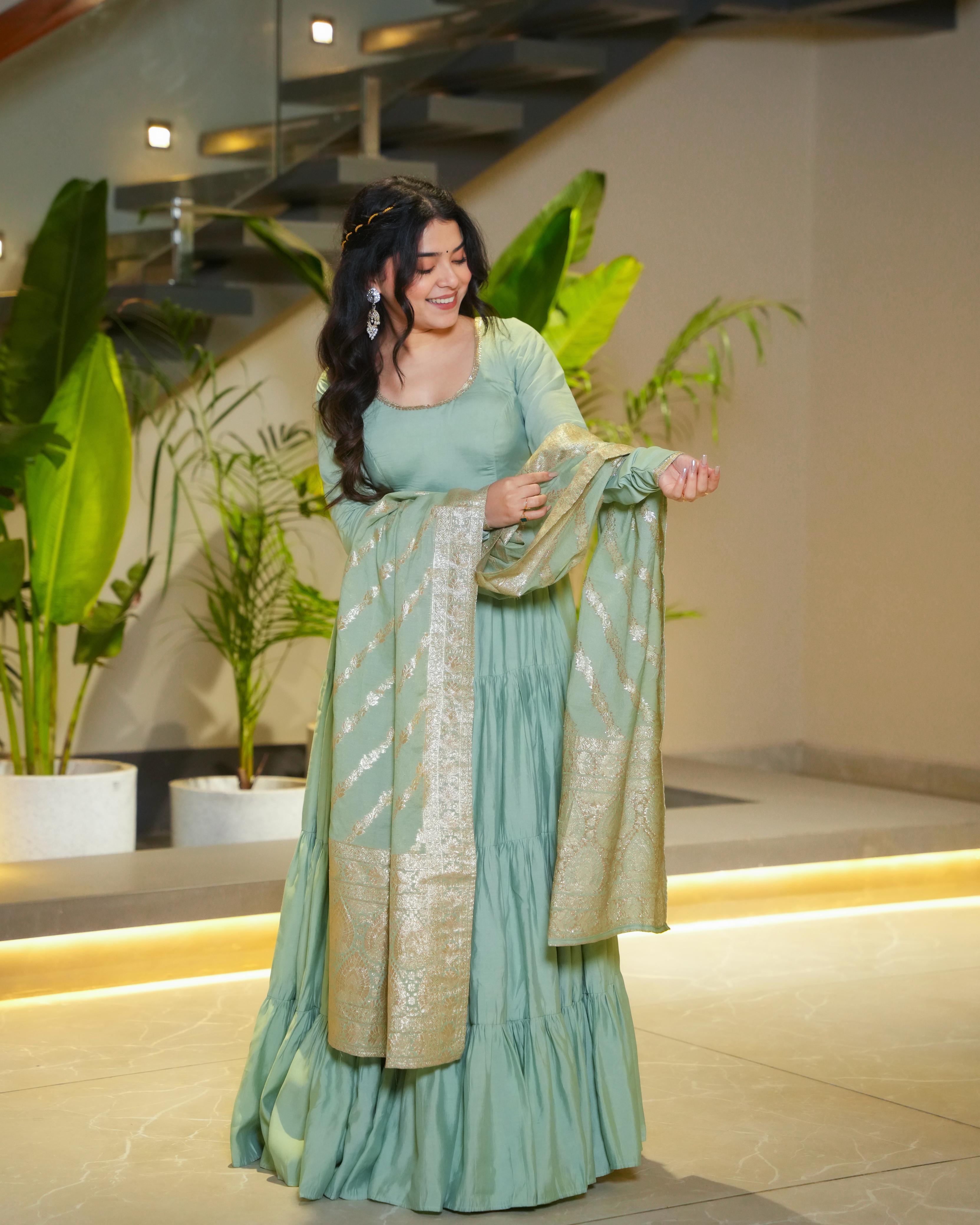 Pista green Roman silk Chanderi Anarkali suit set with Banarasi dupatta, flared Anarkali gown for wedding functions and festive wear, designer frill Anarkali with 9-meter flair, Chanderi silk ethnic suit for women, Banarasi dupatta suit for reception and party wear, pista color Anarkali dress for haldi, mehendi, or Eid, lightweight Anarkali kurta pant set with traditional embroidery.